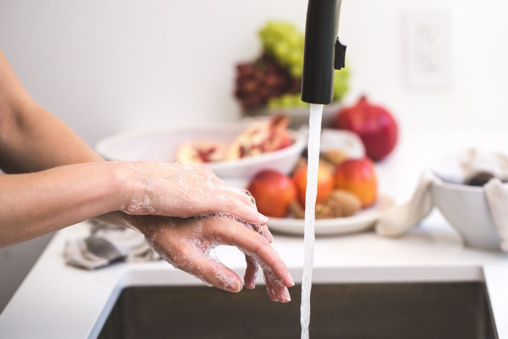 cleaning hands at faucet