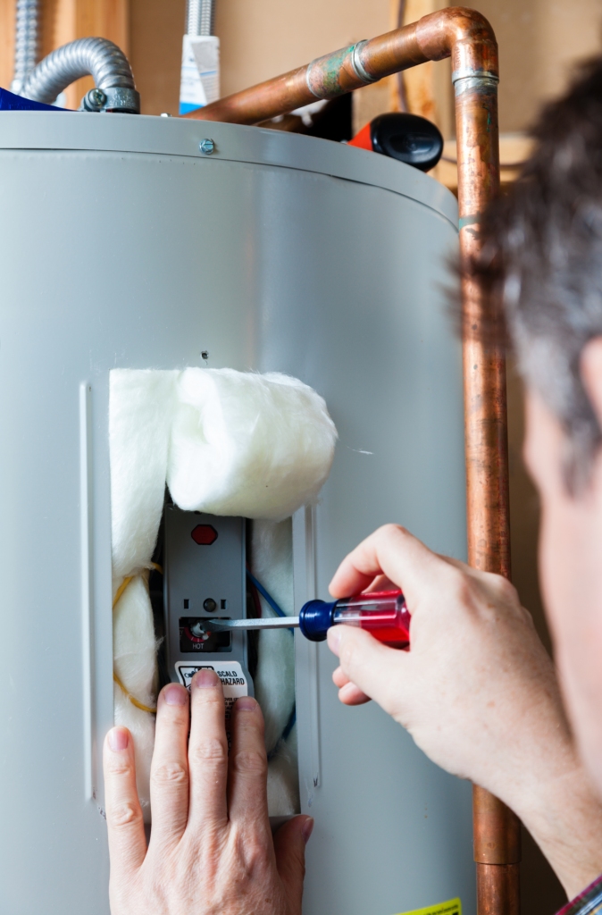 man doing maintenance on water heater electrical panel